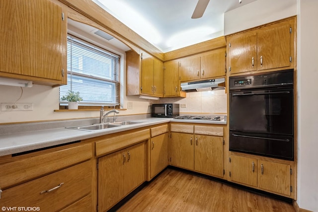 kitchen with sink, decorative backsplash, ceiling fan, black appliances, and light hardwood / wood-style flooring