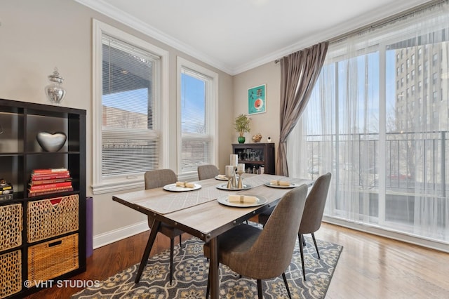 dining space featuring hardwood / wood-style flooring and ornamental molding