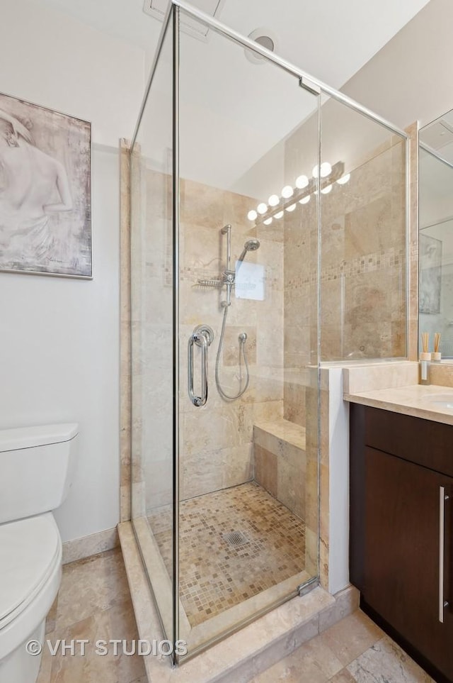 bathroom featuring an enclosed shower, vanity, and toilet