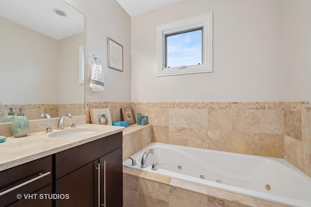 bathroom with vanity and tiled bath