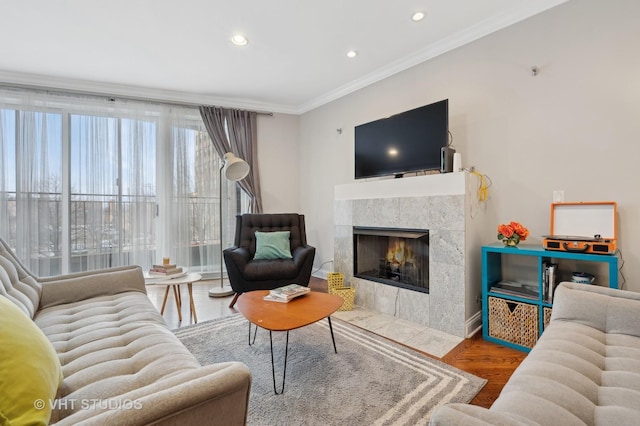 living room featuring crown molding, a tile fireplace, and hardwood / wood-style flooring