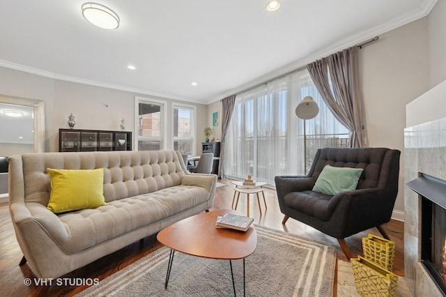 living room featuring hardwood / wood-style flooring, crown molding, and plenty of natural light