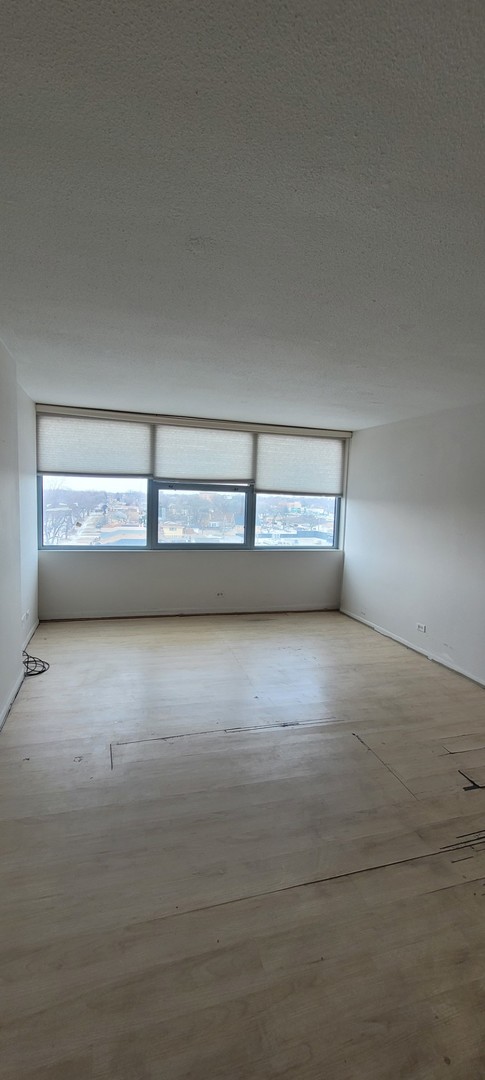 unfurnished room featuring a textured ceiling, light hardwood / wood-style flooring, and a healthy amount of sunlight