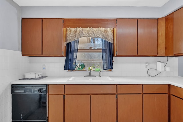 kitchen featuring black dishwasher, sink, and decorative backsplash