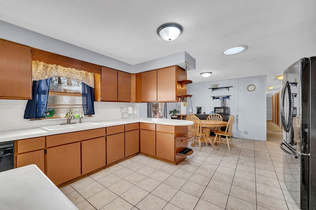 kitchen featuring tile countertops, sink, decorative backsplash, and black appliances