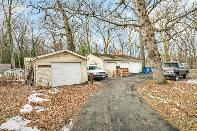 exterior space with a garage and an outbuilding