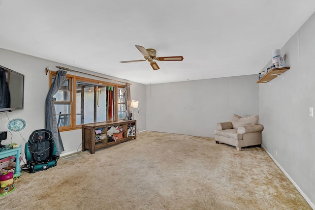 living area featuring ceiling fan and carpet flooring