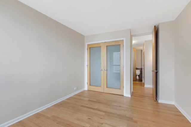 empty room featuring light hardwood / wood-style flooring and french doors