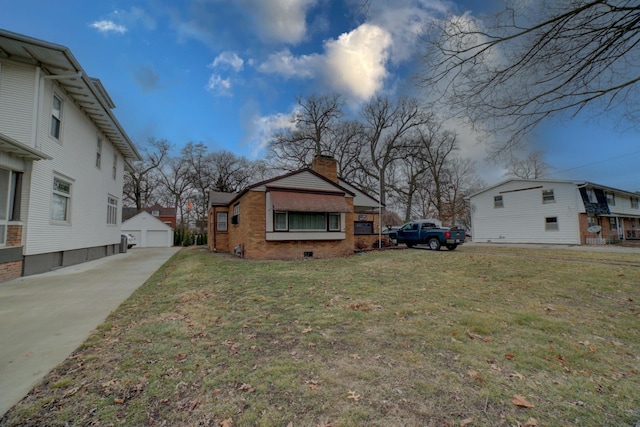 view of side of property with a garage, an outdoor structure, and a lawn