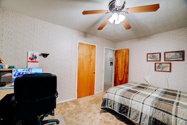 carpeted bedroom with ceiling fan and a textured ceiling