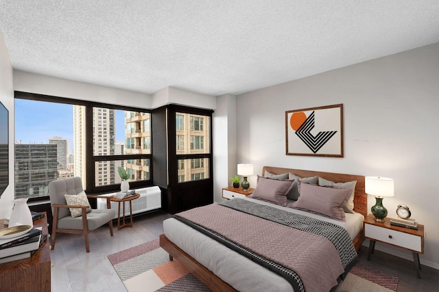 bedroom with hardwood / wood-style flooring and a textured ceiling