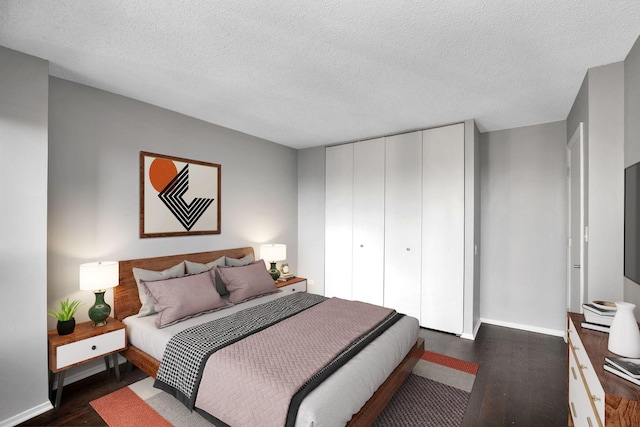 bedroom with dark hardwood / wood-style flooring, a closet, and a textured ceiling