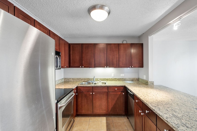 kitchen featuring sink, light stone counters, light tile patterned floors, kitchen peninsula, and stainless steel appliances