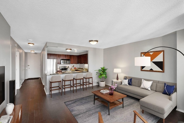 living room featuring dark hardwood / wood-style floors and a textured ceiling