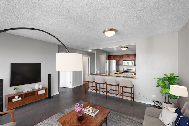 living room featuring dark hardwood / wood-style flooring and a textured ceiling