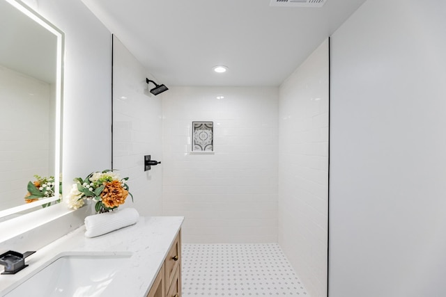 bathroom featuring vanity and tiled shower