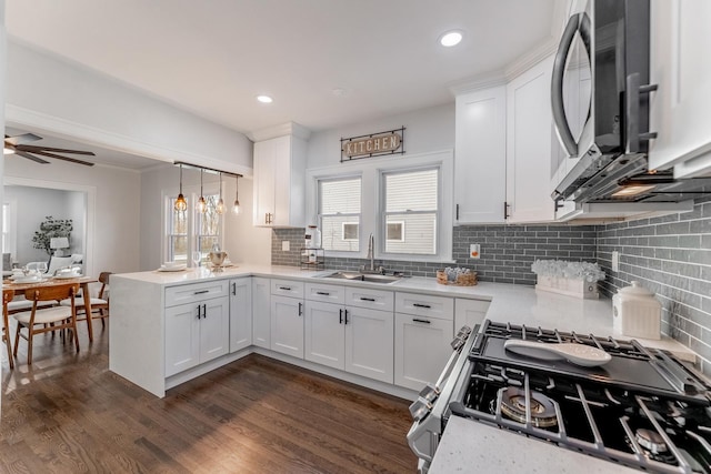 kitchen with stainless steel appliances, decorative light fixtures, sink, and white cabinets