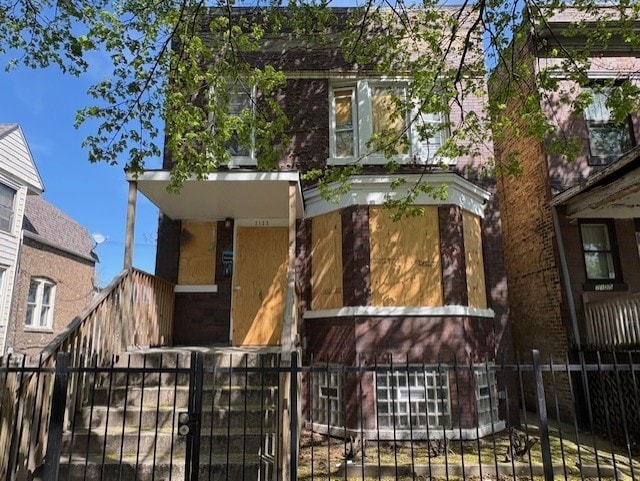 view of front of home featuring brick siding, a gate, and a fenced front yard