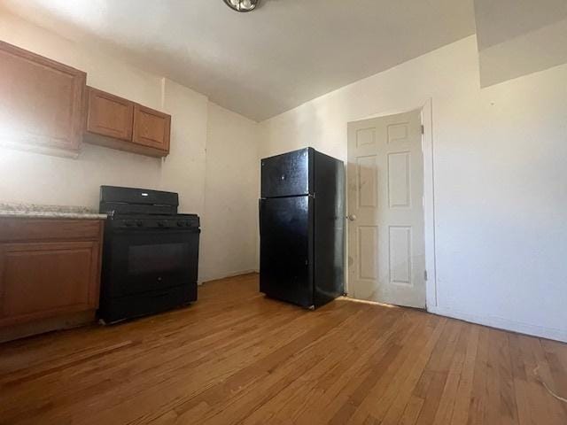 kitchen with hardwood / wood-style floors and black appliances