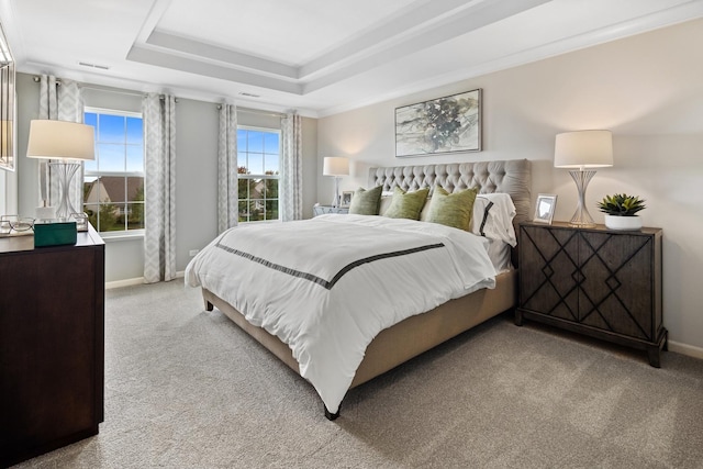 carpeted bedroom with crown molding and a tray ceiling