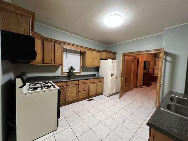 kitchen with sink, white appliances, and light tile patterned floors