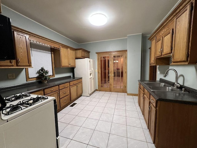 kitchen with sink, light tile patterned floors, white appliances, and french doors