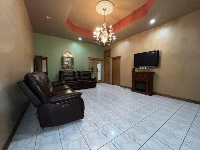 tiled living room featuring a raised ceiling and a chandelier