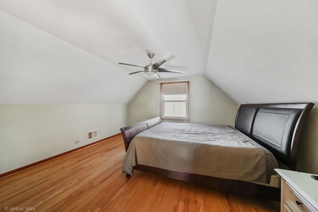 bedroom with ceiling fan, lofted ceiling, and light wood-type flooring