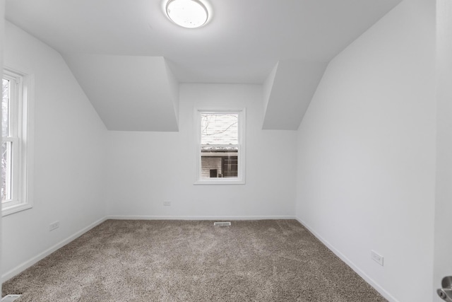 bonus room with lofted ceiling and carpet floors