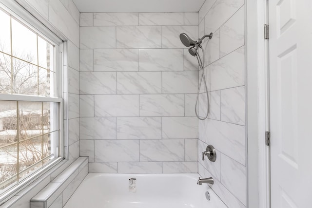 bathroom featuring tiled shower / bath combo and a wealth of natural light