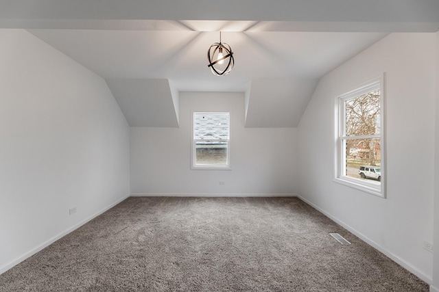 bonus room with a wealth of natural light, vaulted ceiling, and carpet flooring