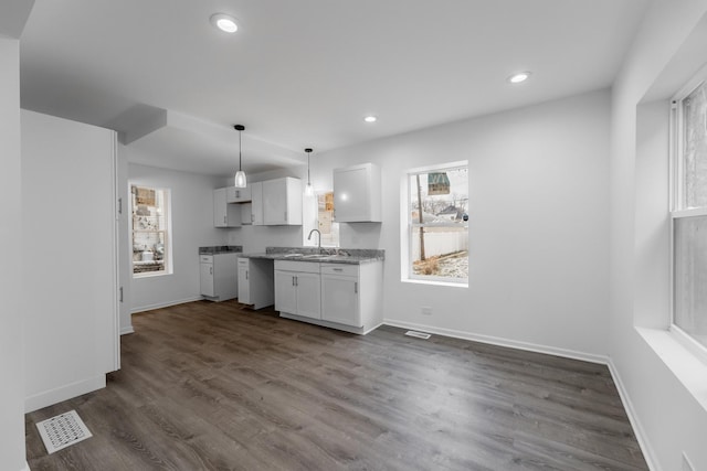 kitchen with white cabinetry, sink, a wealth of natural light, and pendant lighting