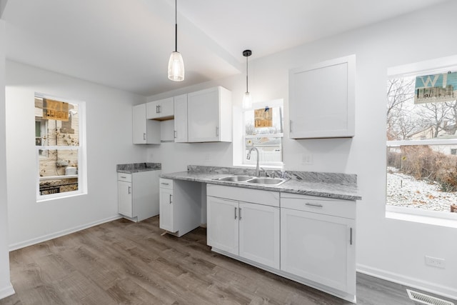 kitchen with pendant lighting, sink, light hardwood / wood-style flooring, and white cabinets