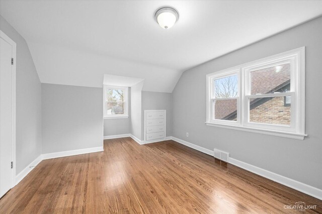 basement featuring wood-type flooring and water heater