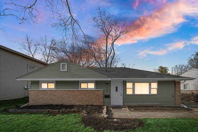 view of front of property featuring a front yard and brick siding