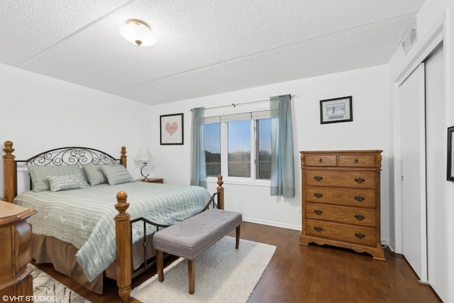 bedroom with dark wood-type flooring, a closet, and a textured ceiling