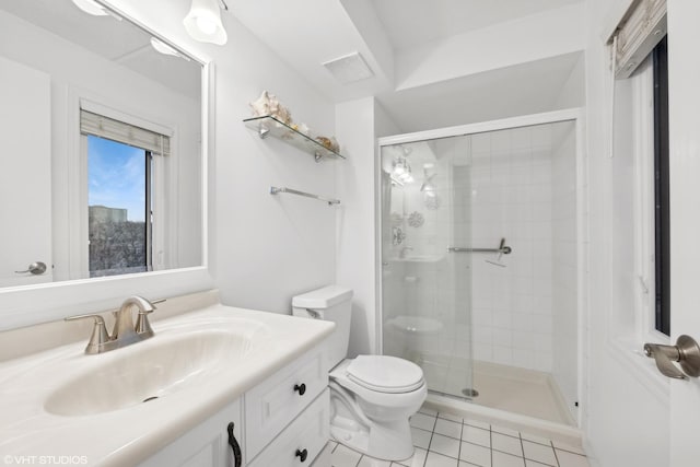 bathroom with a shower with door, vanity, tile patterned floors, and toilet