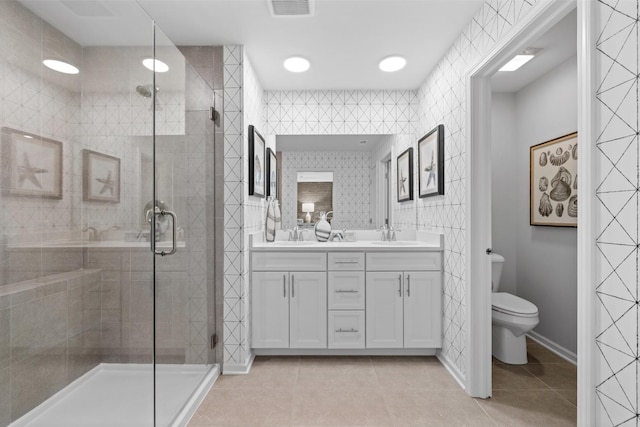 bathroom with tile patterned flooring, tile walls, vanity, a shower with shower door, and toilet