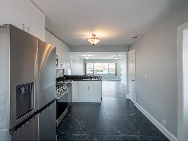 kitchen with white cabinetry, appliances with stainless steel finishes, kitchen peninsula, and sink