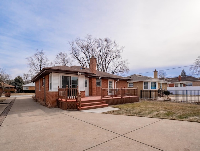 single story home featuring a wooden deck and a front yard