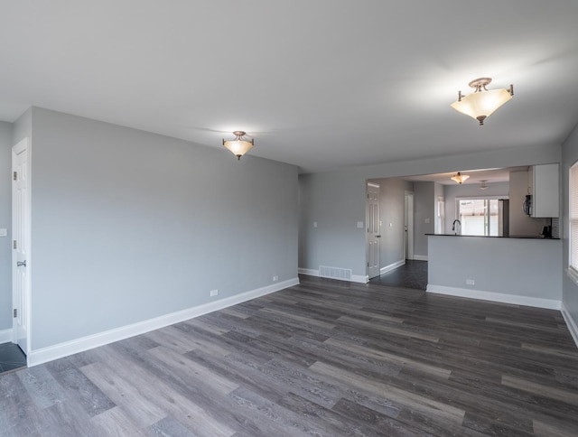 unfurnished living room featuring dark wood-type flooring