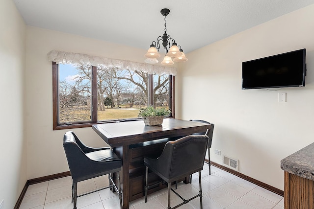 dining room featuring light tile patterned floors and a chandelier