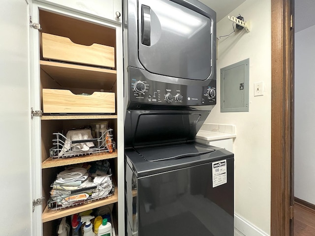 laundry area with stacked washer and dryer and electric panel