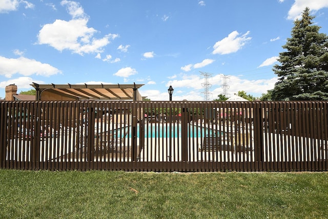 view of gate featuring a community pool and a yard