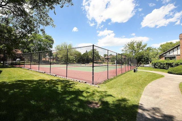 view of tennis court featuring a lawn