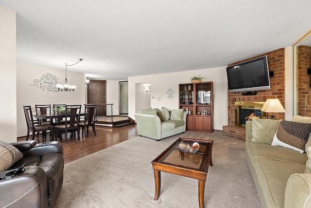 carpeted living room featuring an inviting chandelier, a fireplace, and a textured ceiling