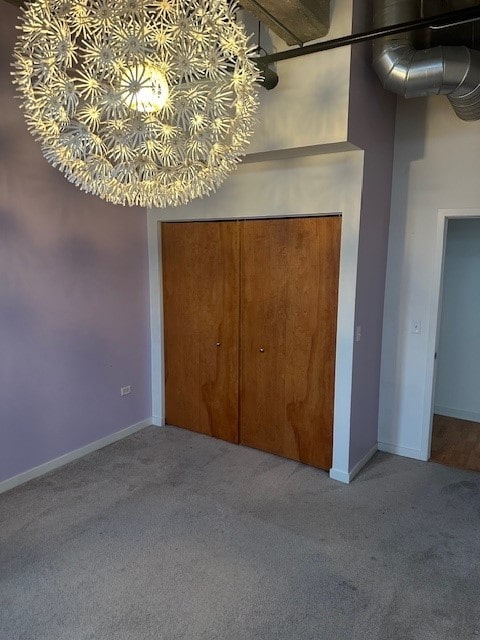 unfurnished bedroom featuring light colored carpet, a closet, and a high ceiling