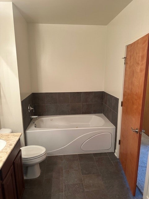 bathroom featuring vanity, a bathing tub, and toilet