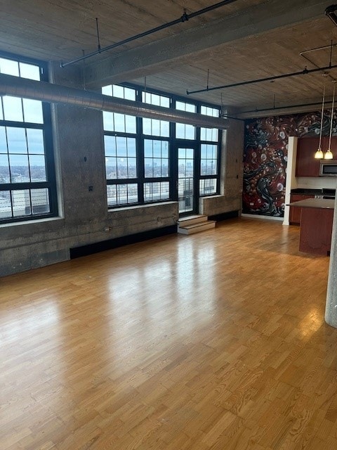 unfurnished living room with a high ceiling and hardwood / wood-style floors