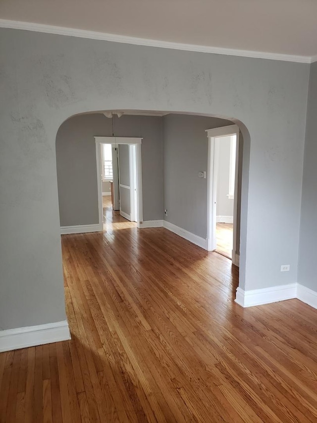 empty room featuring crown molding and light hardwood / wood-style flooring